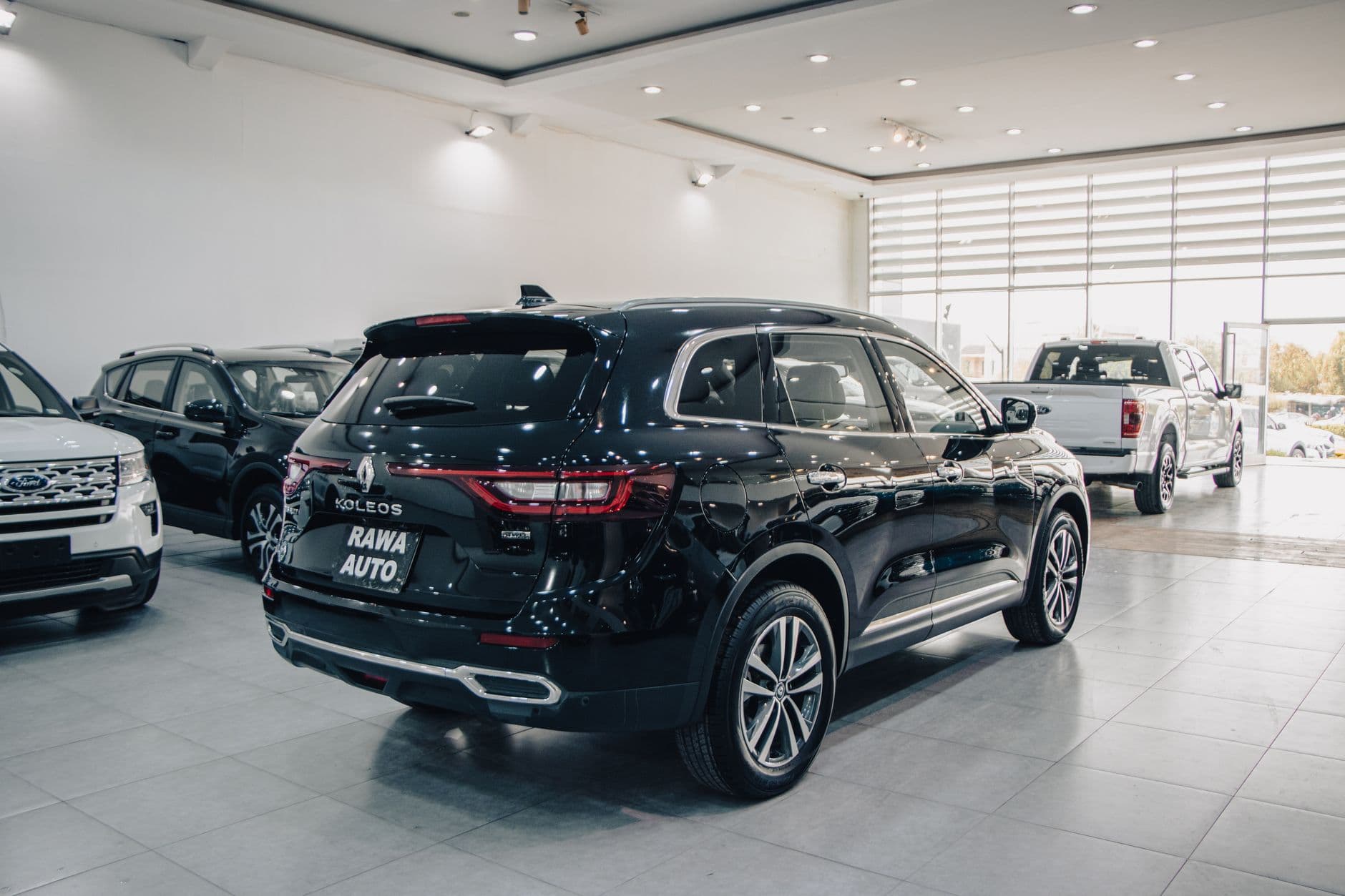 Spacious modern showroom featuring luxury cars on display.